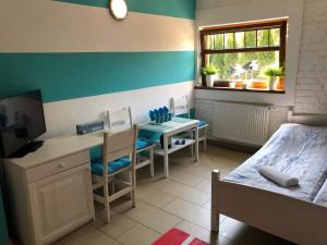 a bedroom with a desk and a bed and a desk with a computer at Villa Papaj in Międzyzdroje