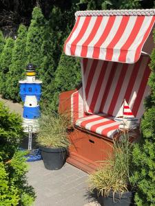 a red and white umbrella and a lighthouse in a garden at Villa Papaj in Międzyzdroje