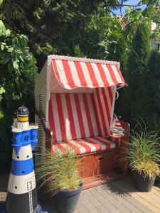 a striped chair and a lighthouse in a garden at Villa Papaj in Międzyzdroje