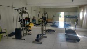 une salle de sport avec plusieurs tapis de course et machines dans une pièce dans l'établissement FLAT VILA DO MAR, à Aquiraz
