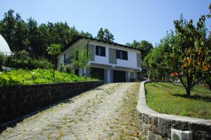 uma casa numa estrada de terra ao lado de uma parede de pedra em Il Convivio Affittacamere em Rofrano