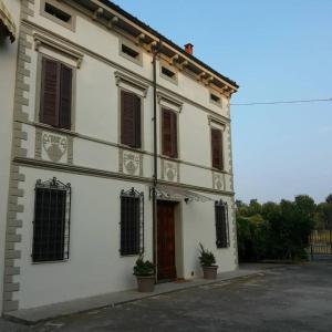 un edificio bianco con finestre e porta di B&B Il Ponticello a Gualtieri