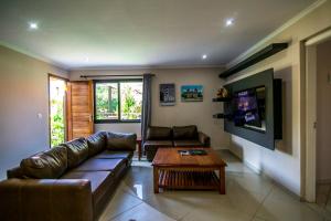 a living room with a leather couch and a coffee table at Ossanzaia Bilene Lodge in Vila Praia Do Bilene