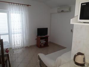 a small living room with a television and a couch at Apartments Beg in Rab