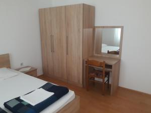 a bedroom with a bed and a desk and a mirror at Apartments Beg in Rab