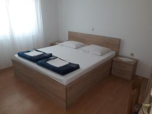 a bedroom with a bed with a blue blanket on it at Apartments Beg in Rab