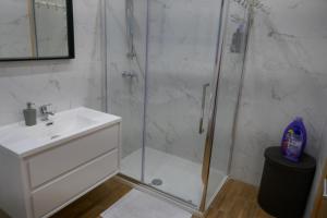 y baño con ducha, lavabo y cabina de ducha acristalada. en Calypso Court, en Mellieħa 7 fotos más