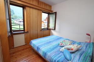 una camera con un letto e due finestre di Varabeta a Forni di Sopra