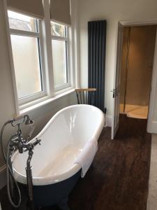 a bath tub in a bathroom with a window at Avenue House in Bakewell