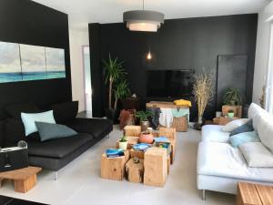 sala de estar con sofá, mesas y TV en Résidence des trois pins, en Plomeur
