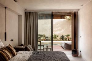 a bedroom with a bed and a view of a patio at OKU Ibiza in San Antonio +37 photos