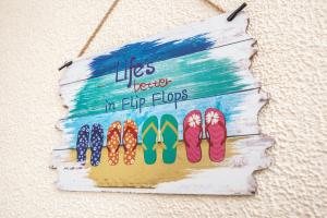 a sign that reads lives better in flip flops at Babbacombe Apartments in Torquay