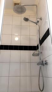 a shower in a bathroom with a black and white tiles at De Tuinkamer-----Privé diner op de kamer mogelijk!!! in Hoogeveen +33 photos