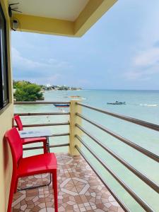 einen roten Stuhl auf dem Balkon mit Meerblick in der Unterkunft Sascha's Resort Oslob in Oslob