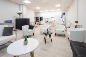 - une salle d'attente avec des tables et des chaises blanches dans l'établissement Dream in Santiago, à Saint-Jacques-de-Compostelle