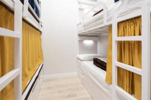 Zimmer mit Etagenbetten und gelben Vorhängen in der Unterkunft Dream in Santiago in Santiago de Compostela