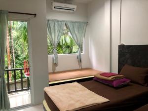 een kamer met een raam, een bed en een balkon bij chillchillsangkhlaburi โรงแรมชิลชิลสังขละบุรี in Sangkhla Buri