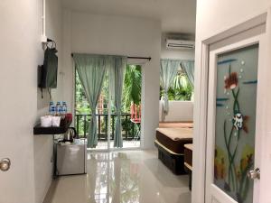 een slaapkamer met een bed en een deur naar een balkon bij chillchillsangkhlaburi โรงแรมชิลชิลสังขละบุรี in Sangkhla Buri