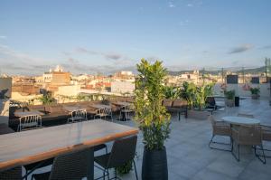a rooftop patio with tables and chairs and a city at Silken Ramblas in Barcelona