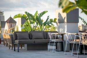a couch on a patio with tables and chairs at Silken Ramblas in Barcelona