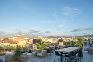 a patio with tables and chairs and a view of a city at Silken Ramblas in Barcelona