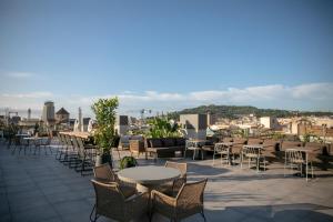 a patio with tables and chairs on a roof at Silken Ramblas in Barcelona