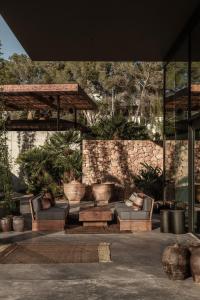 a patio with two couches and a stone wall at OKU Ibiza in San Antonio