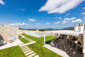 a villa with a swimming pool and a patio at Thalmargia Villas, Ultimate Peace & Privacy, By ThinkVilla in Rethymno