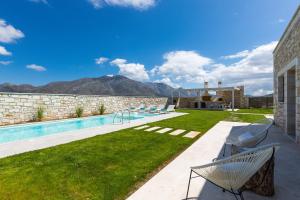 a backyard with a swimming pool and mountains in the background at Thalmargia Villas, Ultimate Peace & Privacy, By ThinkVilla in Rethymno Town