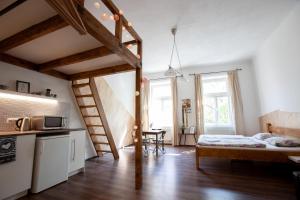 um pequeno quarto com uma cama e uma cozinha com uma escada em Wow Wow Apartment em Praga