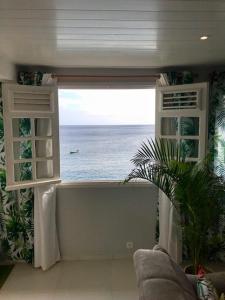 a room with a window with a view of the ocean at Sunset in Schœlcher
