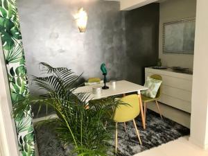 a dining room with a table and some plants at Sunset in Schœlcher