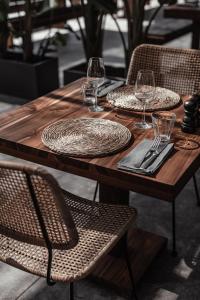 a wooden table with plates and wine glasses on it at OKU Ibiza in San Antonio
