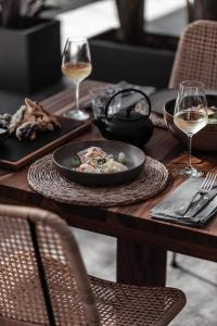 a table with a plate of food and glasses of wine at OKU Ibiza in San Antonio