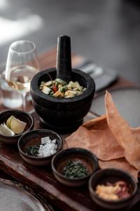 a table with bowls of food and a glass of wine at OKU Ibiza in San Antonio