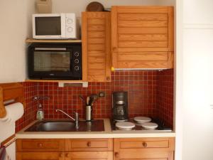 a kitchen with a sink and a microwave at Studio LUMINEUX avec belle TERRASSE sur ESPACES VERTS, 100m PLAGE in Carnac-Plage