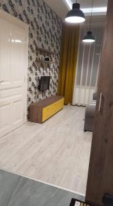 Zimmer mit einer Tür und einem TV an der Wand in der Unterkunft ZEN Apartments Oradea in Oradea
