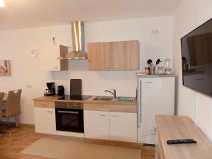 a kitchen with white cabinets and a sink and a microwave at FeWo Zum Kuhturm in Günzburg