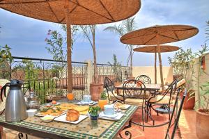a table with food on a patio with umbrellas at Dar Al Hamra in Marrakesh