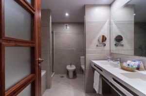 a bathroom with a sink and a shower and a toilet at Hotel MS Maestranza Málaga in Málaga