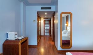 a bedroom with a large mirror and a bed at Hotel MS Maestranza Málaga in Málaga