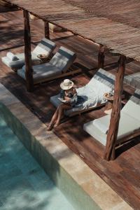 a woman sitting on a bed next to a pool at OKU Ibiza in San Antonio
