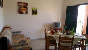 a living room with a table and a tv at agriturismo heaven in Capo Vaticano