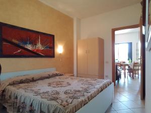 a bedroom with a bed with a painting on the wall at agriturismo heaven in Capo Vaticano