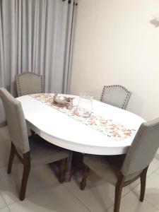 a dining room table with chairs and a tablecloth on it at Embassy Gardens 17 West Rd South Morningside Sandton Johannesburg Secure 2 Bedroom fully furnished apartment with 24hrs security in Johannesburg