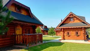 a log cabin with a porch and a house at Ubytovanie Koliba Pacho - Zrub Katka in Prievidza