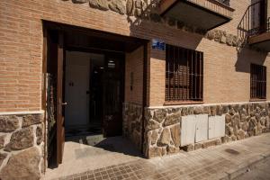 uma entrada para um edifício de tijolos com uma porta em luxury suite em Ciempozuelos