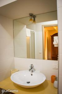 y baño con lavabo y espejo. en Le Casette en Matera