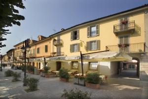 a building with tables and umbrellas on a street at Albergo Ristorante Badellino dal 1917 in Bra