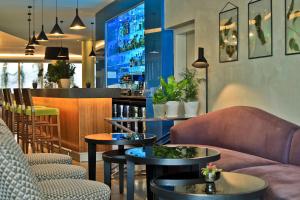 a restaurant with couches and tables and a bar at Botanique Hotel Prague in Prague